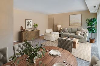 a living room and dining room with a table and chairs
