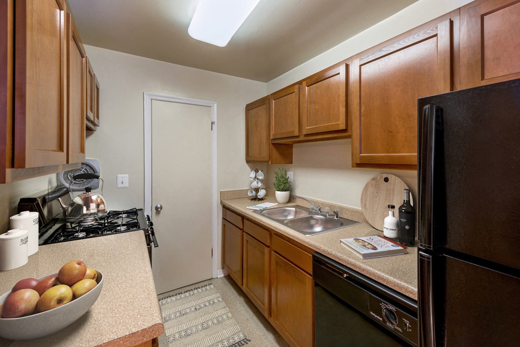 a kitchen with wooden cabinets and a sink and a refrigerator