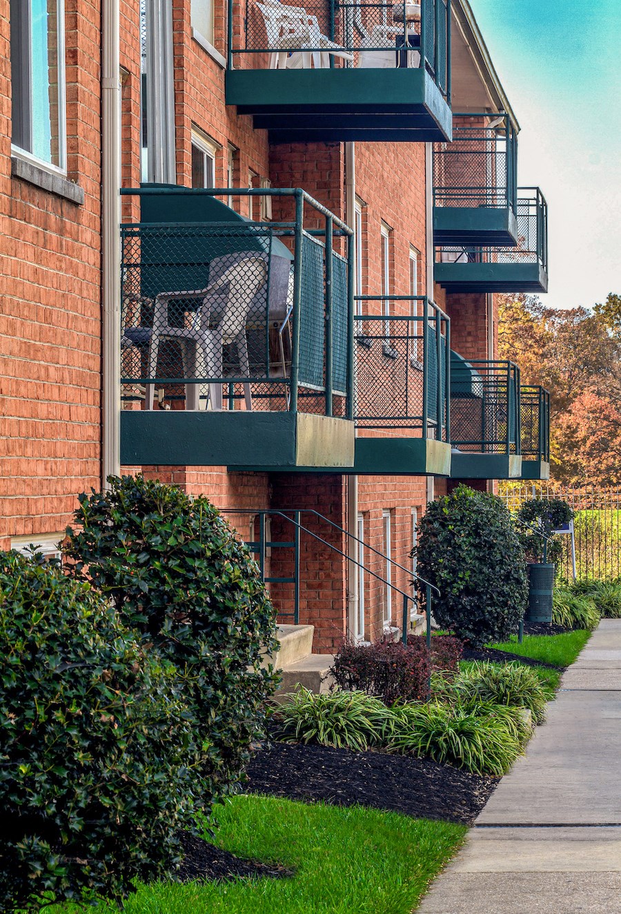 an apartment building with a balcony with two chairs on it