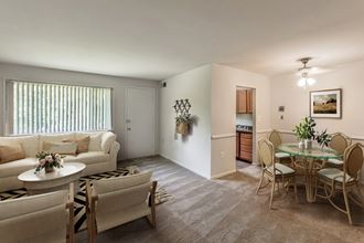 a living room and dining room with a table and chairs
