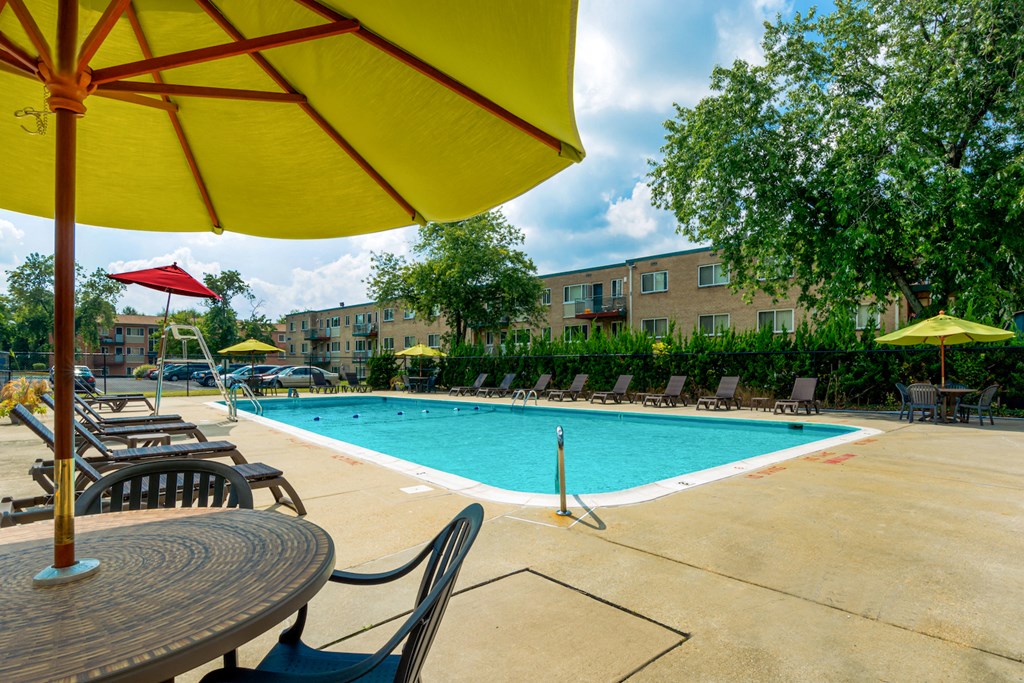 a swimming pool with tables and chairs and umbrellas