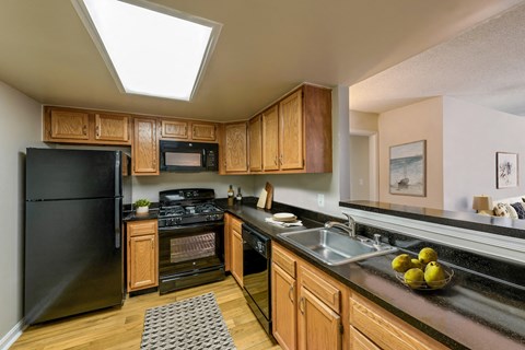 a kitchen with black appliances and wooden cabinets