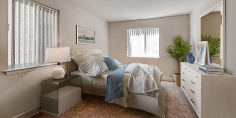 a bedroom with a bed and a dresser and a window