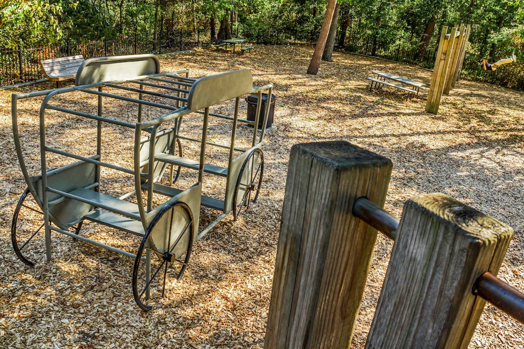 a metal shopping cart and chairs in a park