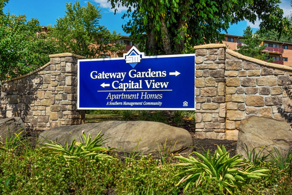 a sign for gateway gardens capital view on a stone wall