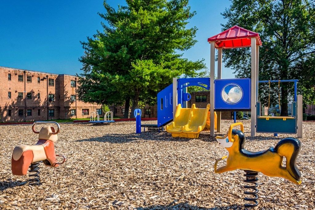 a playground with a bunch of toys and a building in the background