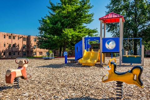 a playground with a bunch of toys and a building in the background