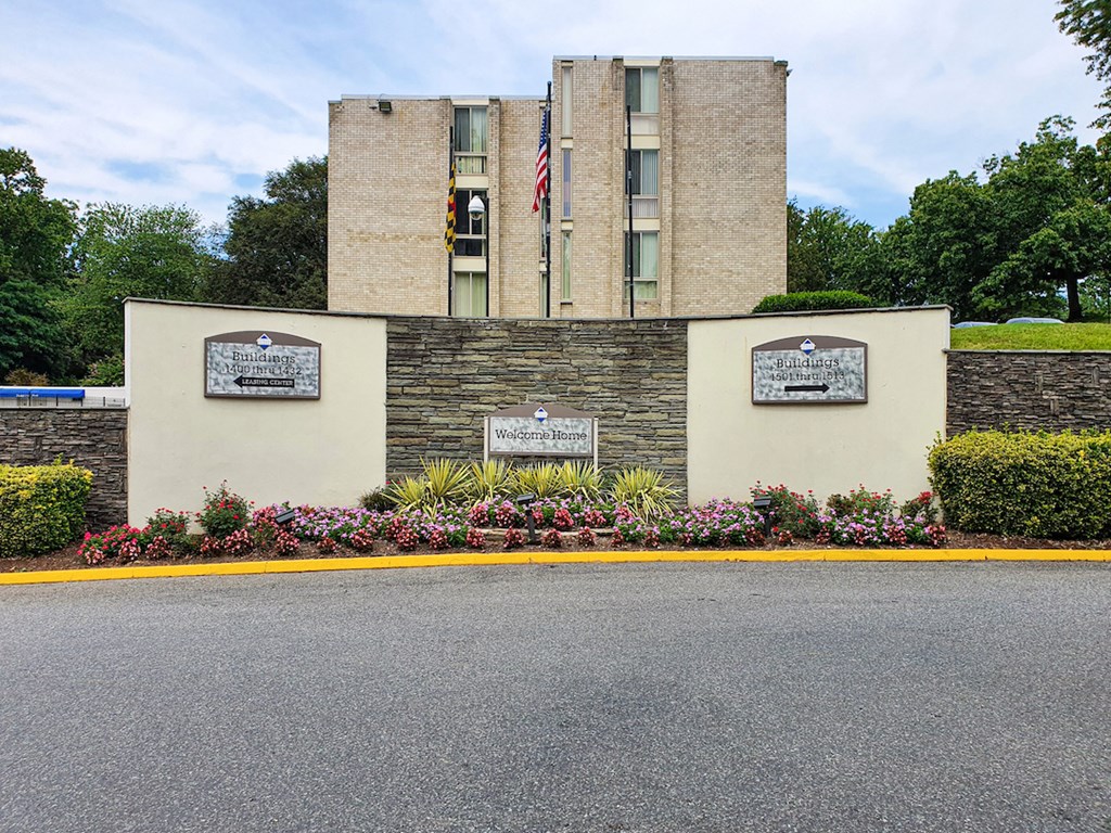 a building with a stone wall and flowers in front of it
