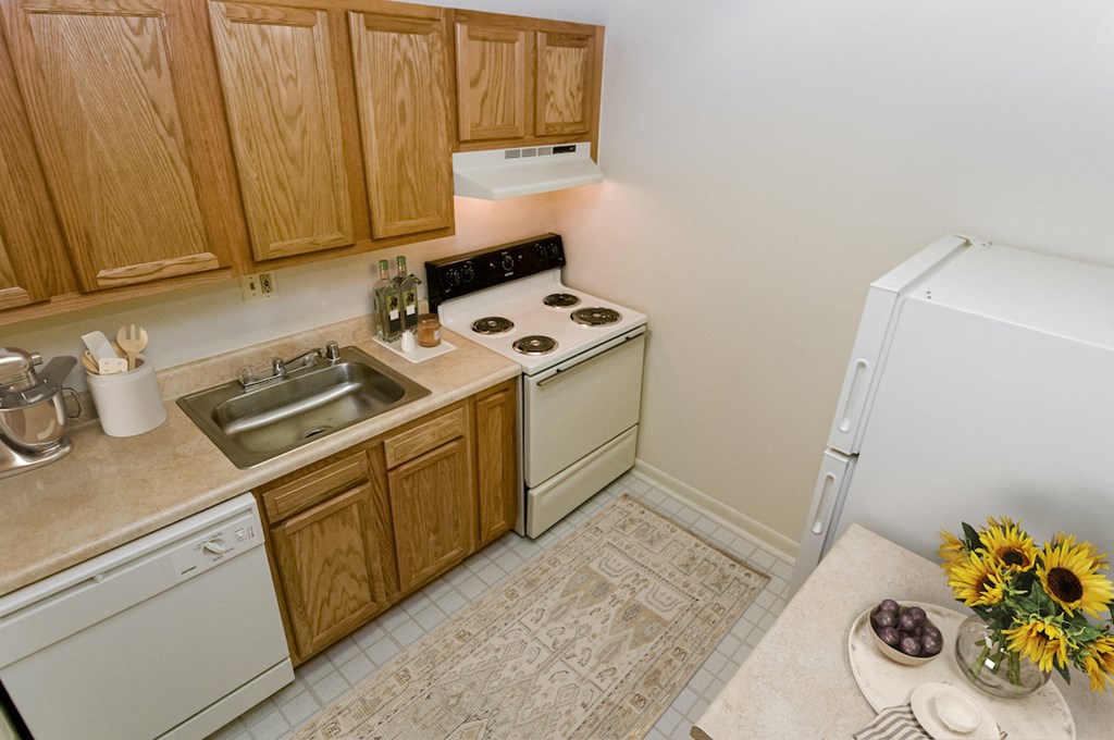 a small kitchen with white appliances and wooden cabinets