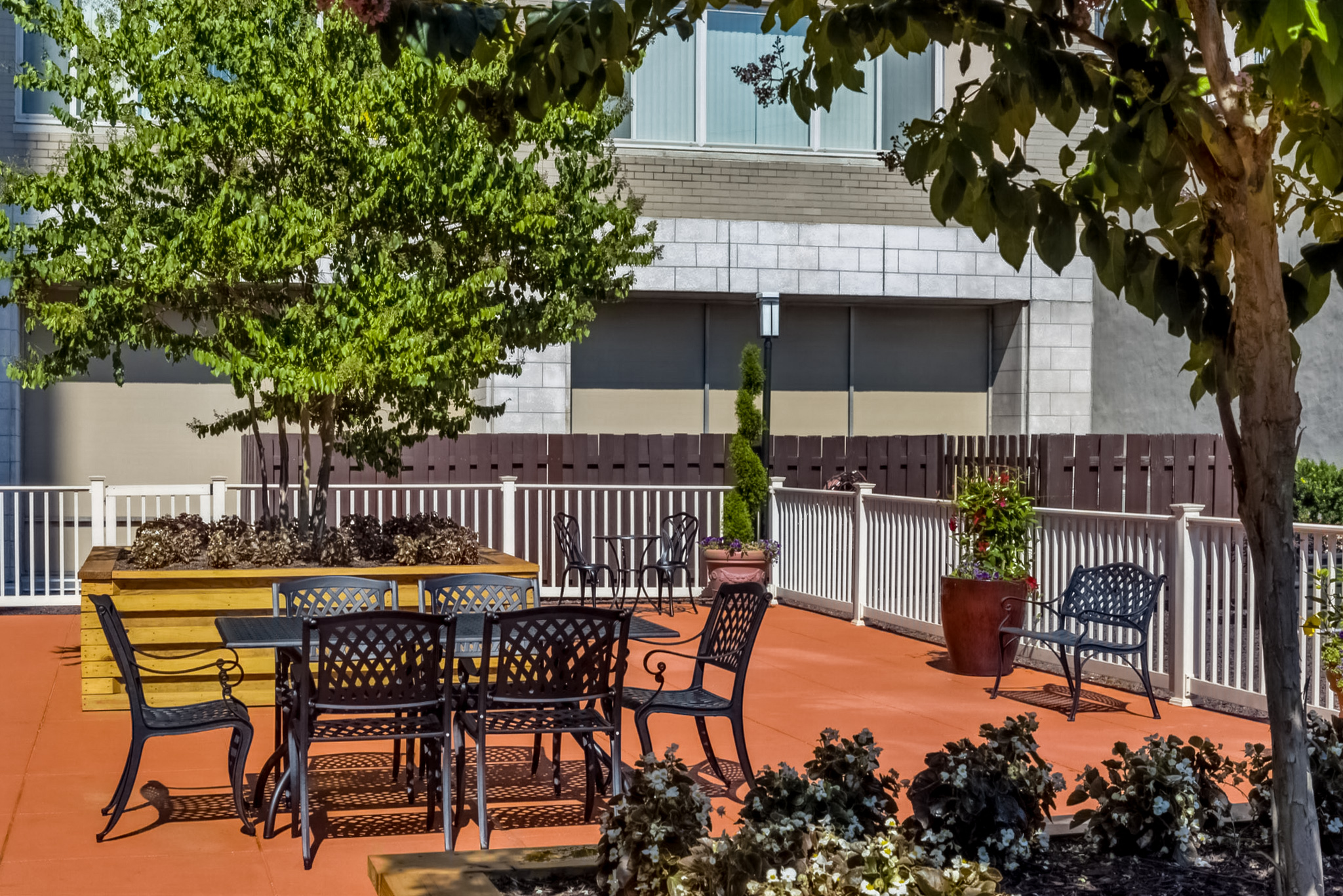 a patio with a table and chairs and trees