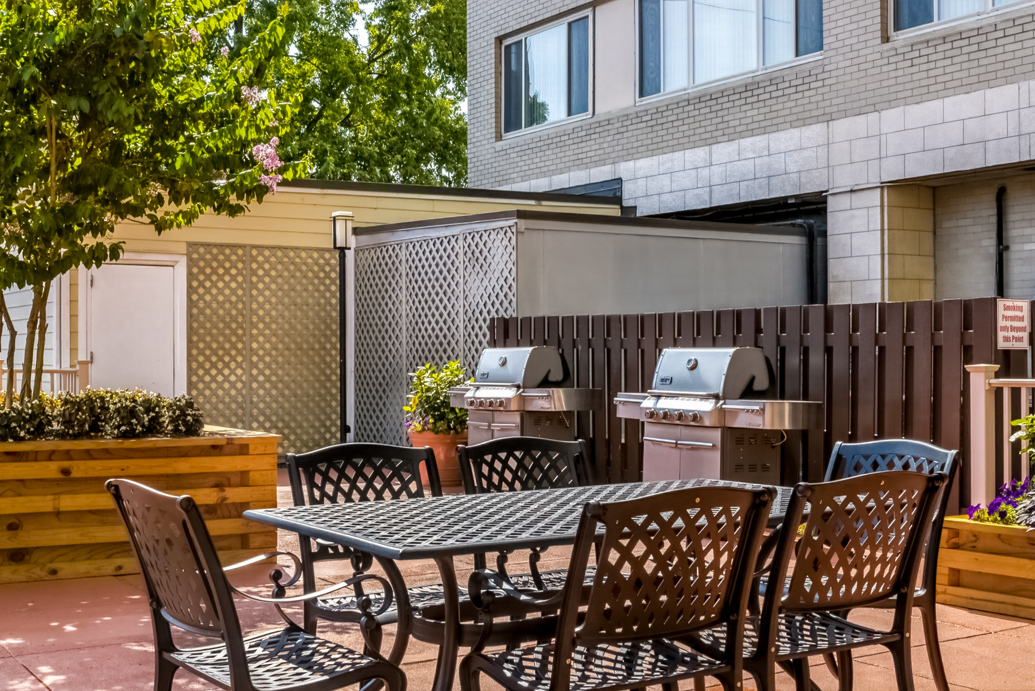 a patio with a table and chairs and a grill