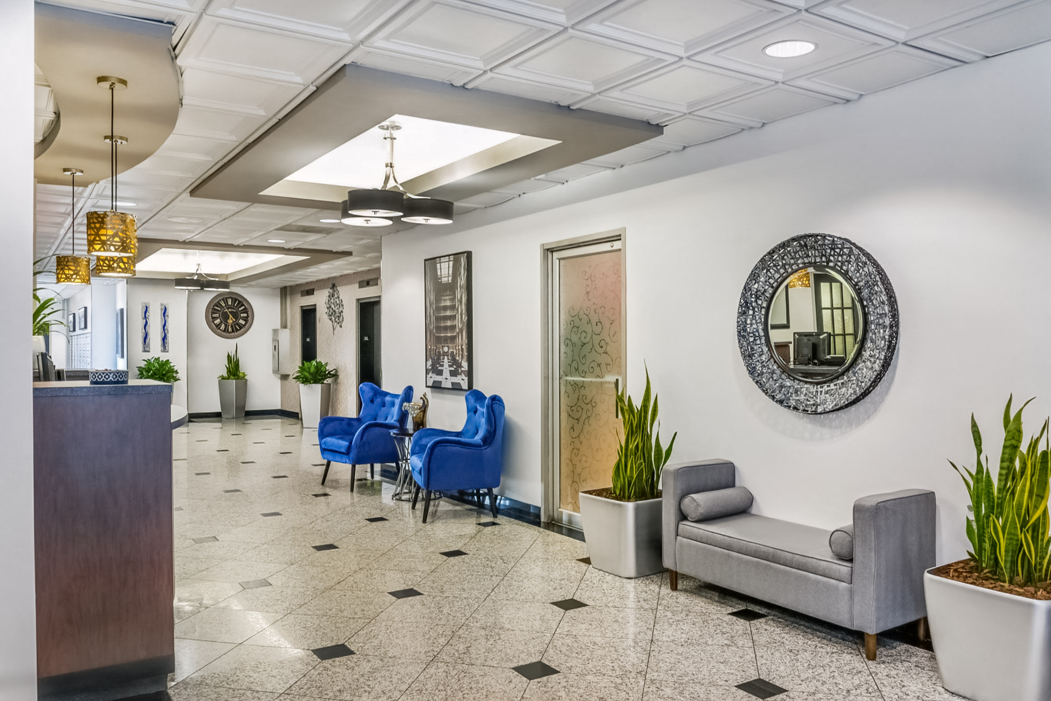 the waiting room of a hospital with blue chairs and a reception desk