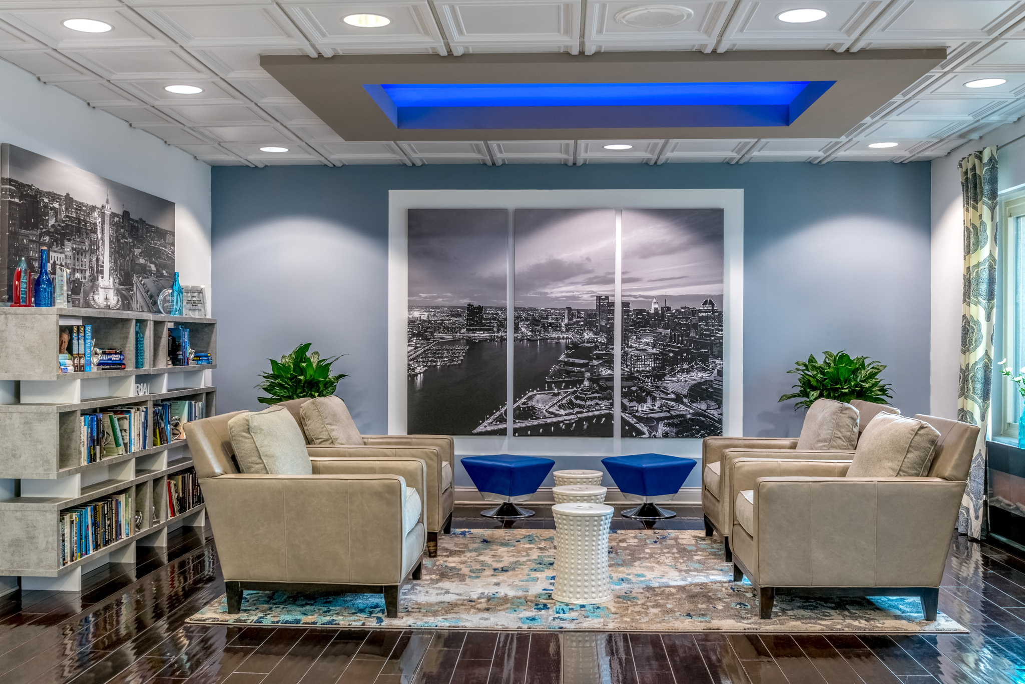 a lounge area with couches and chairs and a large picture on the wall
