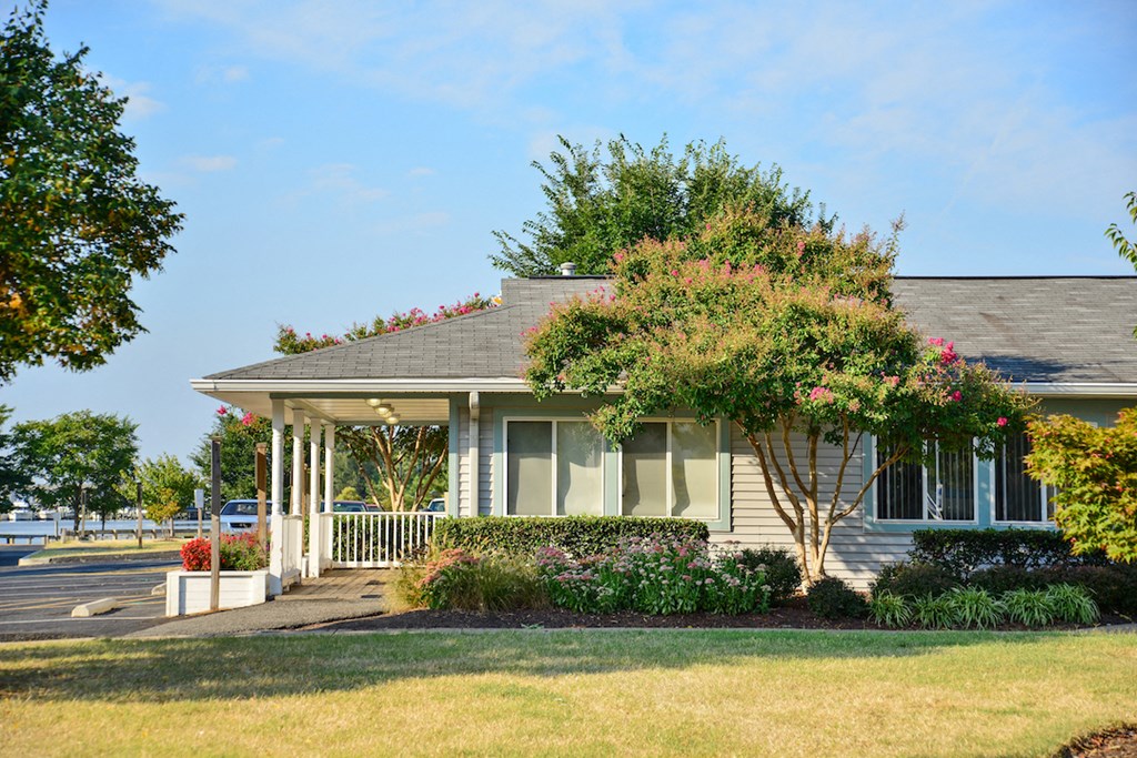 a house with a porch and a tree in front of it