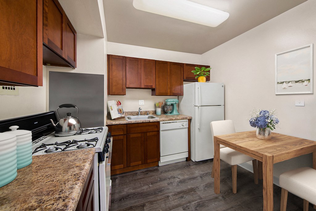 a kitchen with white appliances and a wooden table