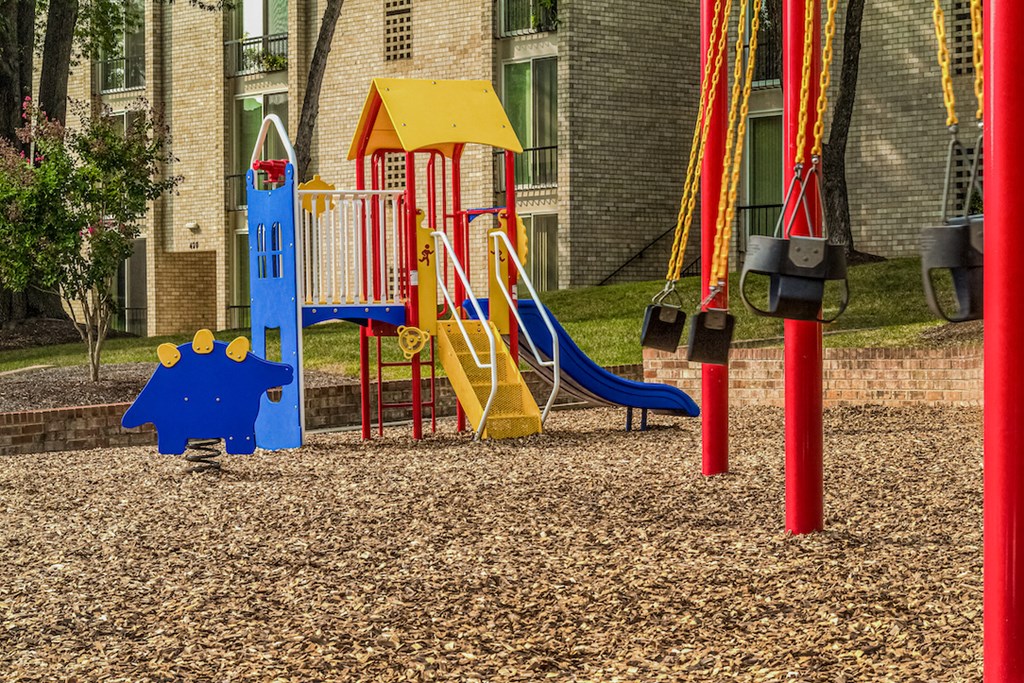 a child playing on a playground in front of a building