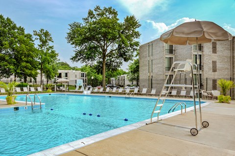 a swimming pool with an umbrella next to a building