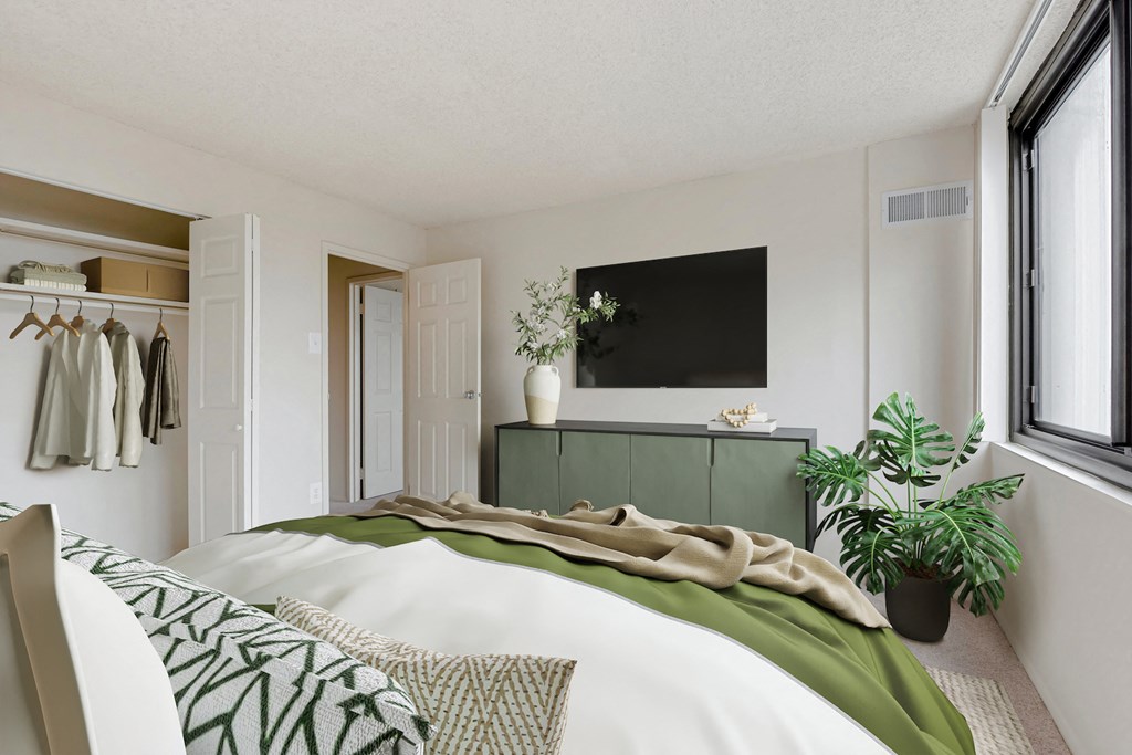 a bedroom with a bed and a tv on the wall