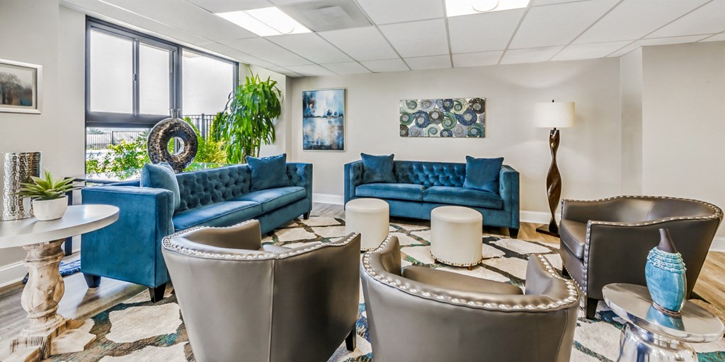 a living room with blue couches and chairs and a table