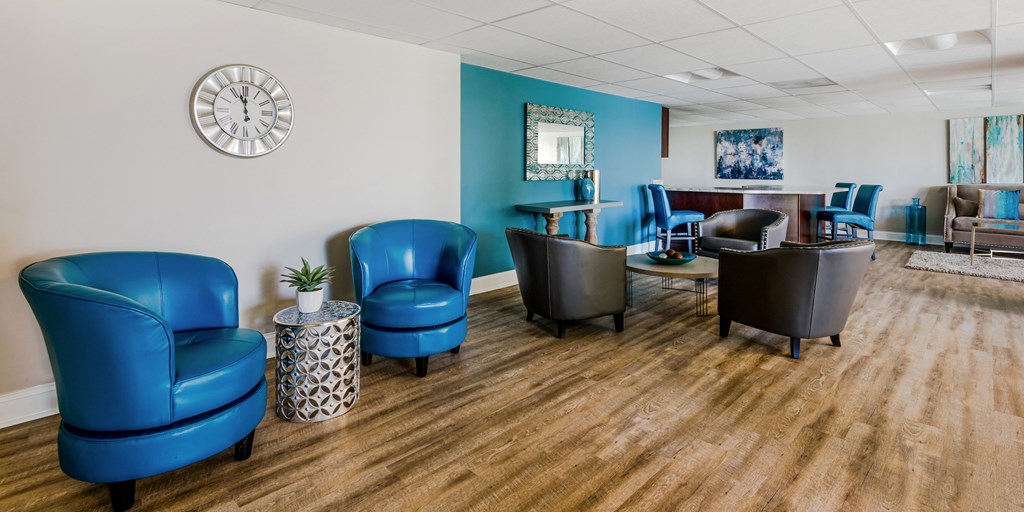 a waiting room with blue chairs and a clock on the wall