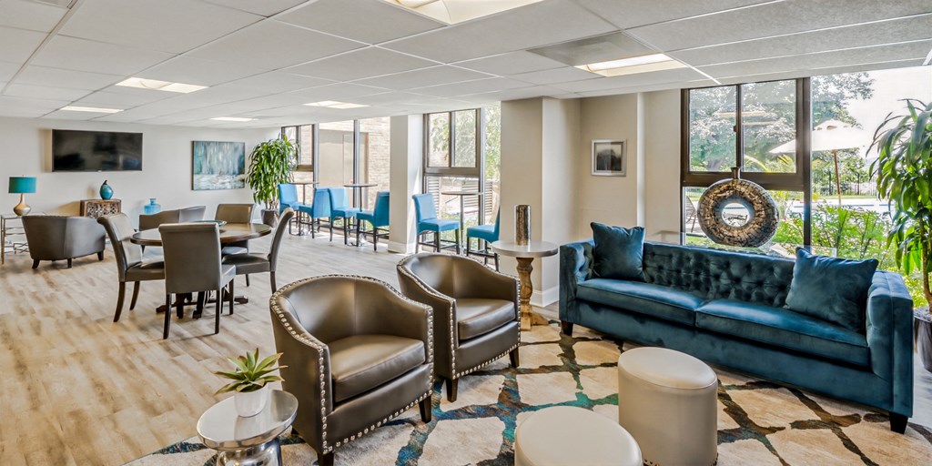 a living room with couches and chairs and a table and chairs in a lobby