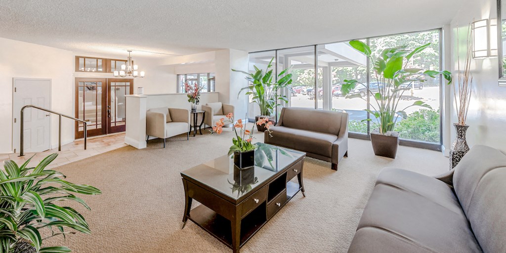 a living room with couches and a coffee table   and a large window