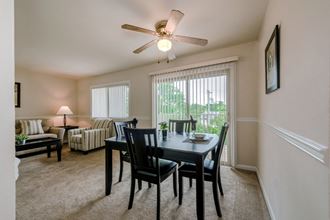 an open living room with a dining room table and a ceiling fan