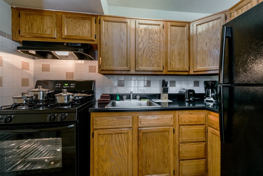 a kitchen with black appliances and wooden cabinets