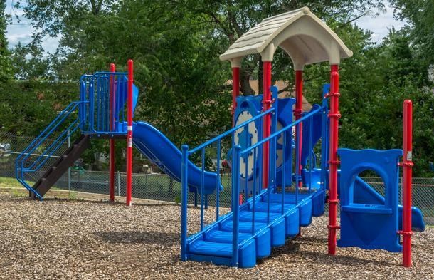 a blue and red playground with a swing set