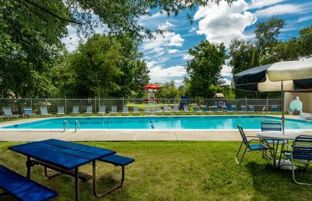 a swimming pool with tables and chairs around it
