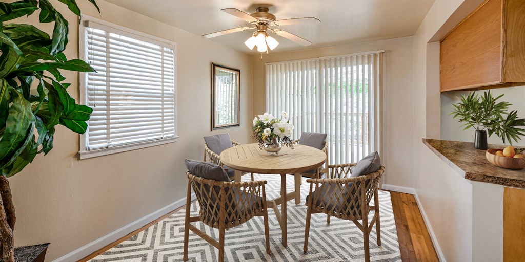 a dining room with a table and chairs and a ceiling fan