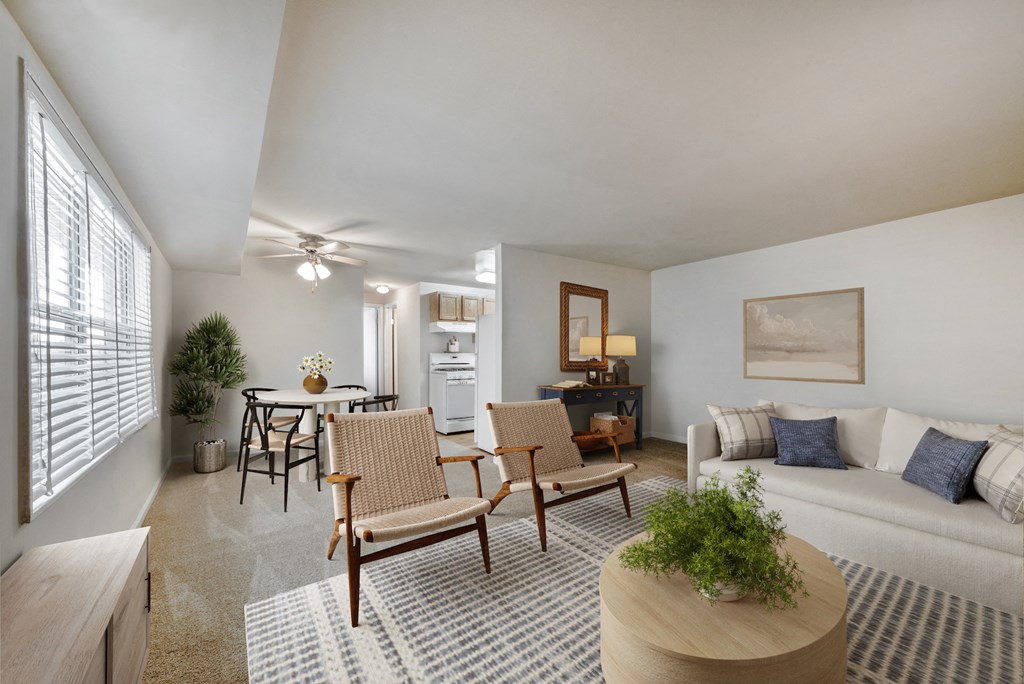 a living room with a couch and chairs and a dining room table