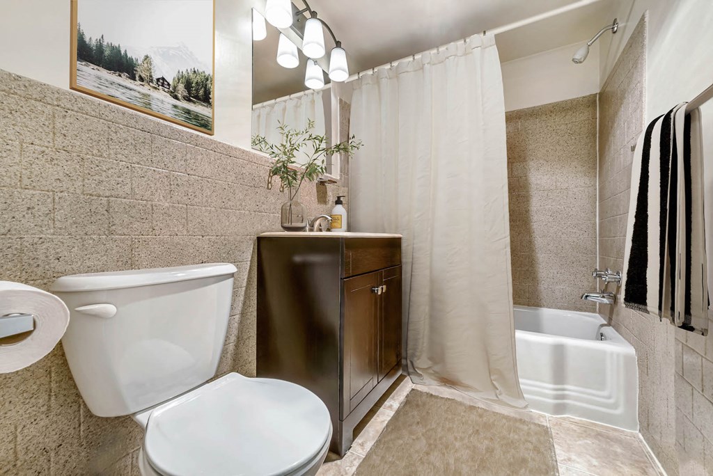 a bathroom with a toilet and a shower and a sink