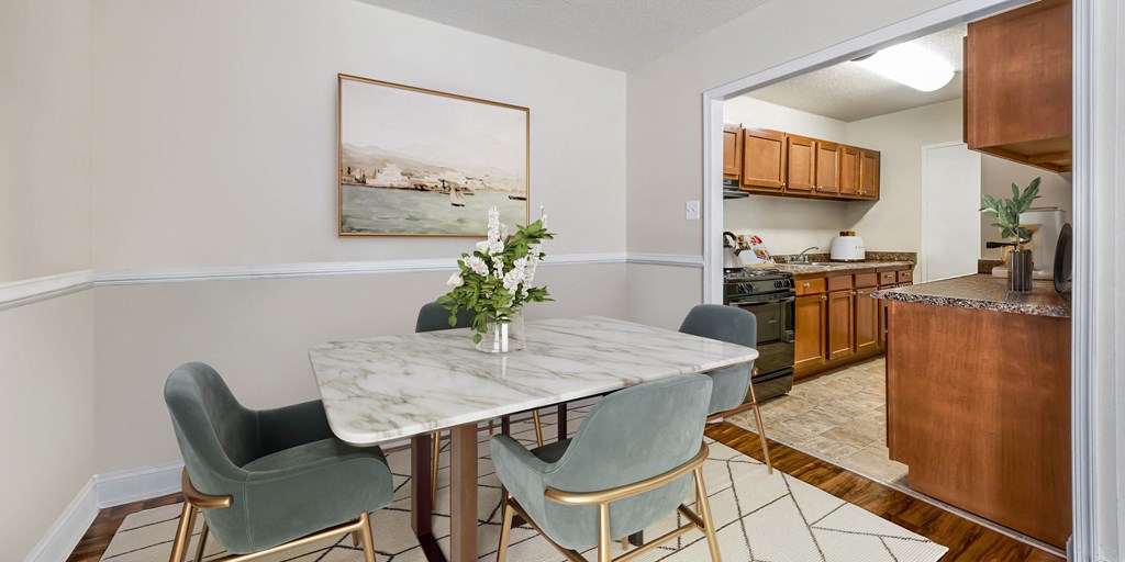 a dining room with a marble table and chairs and a kitchen