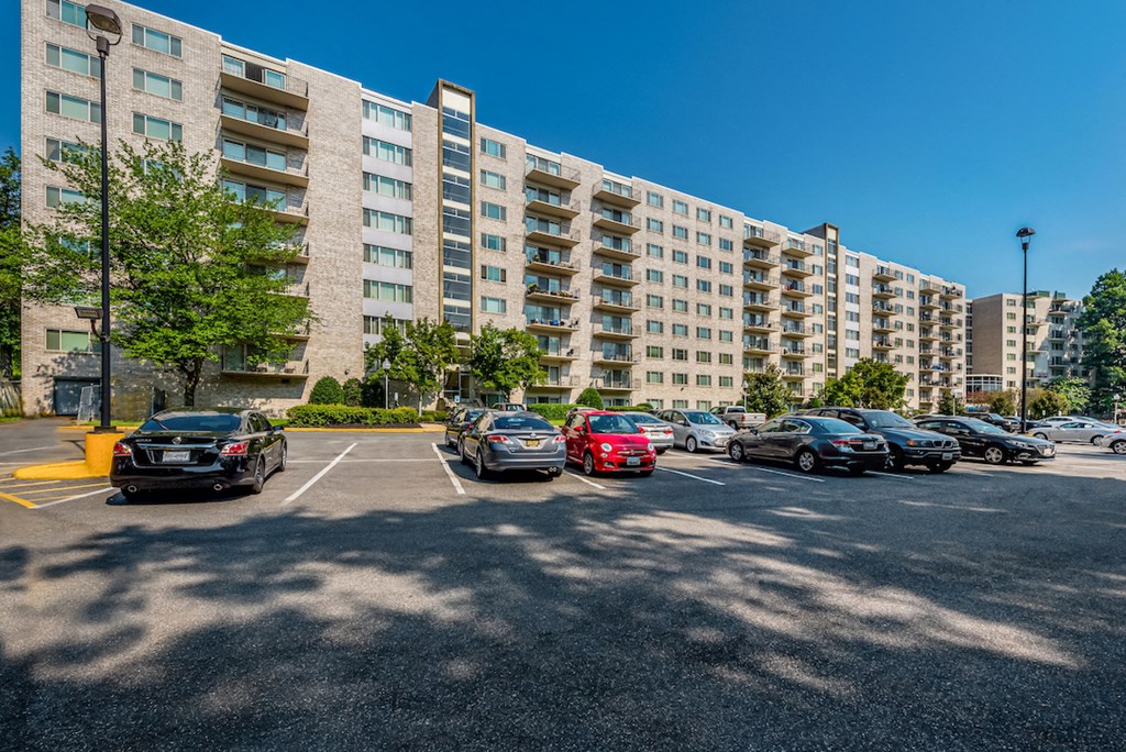 a parking lot with cars parked in front of an apartment building