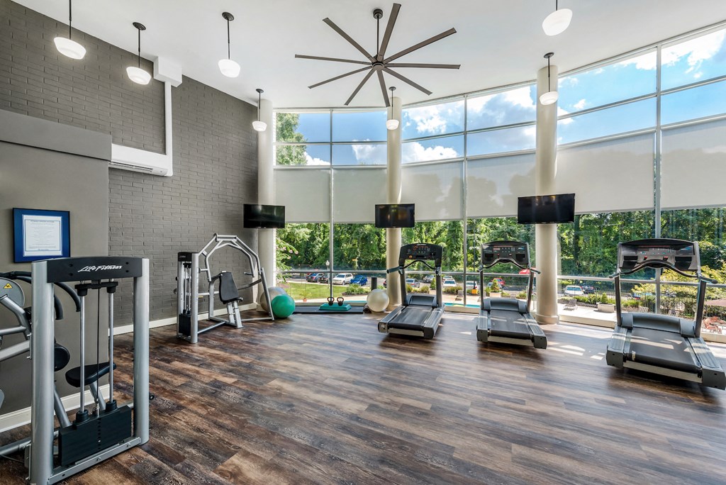 a gym with treadmills and other exercise equipment and a large window