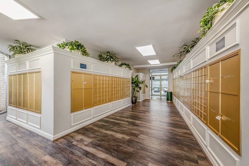 a long hallway with white and gold lockers and wood floors