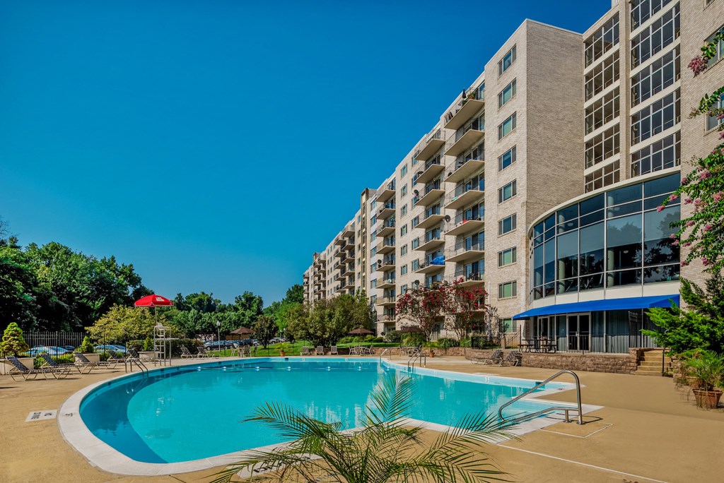 a swimming pool with an apartment building in the background