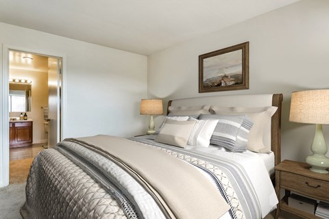 a bedroom with a bed and two lamps and a bathroom