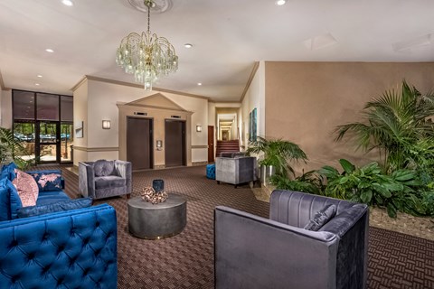 a lobby with couches and chairs and a chandelier