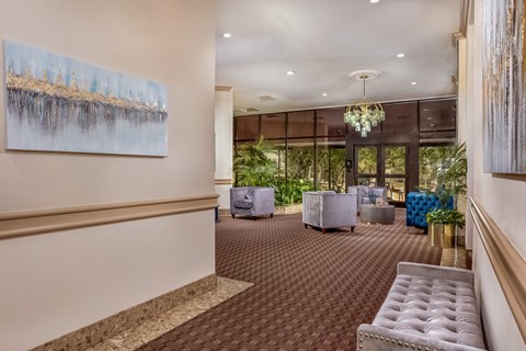 a lobby with couches and chairs and a chandelier