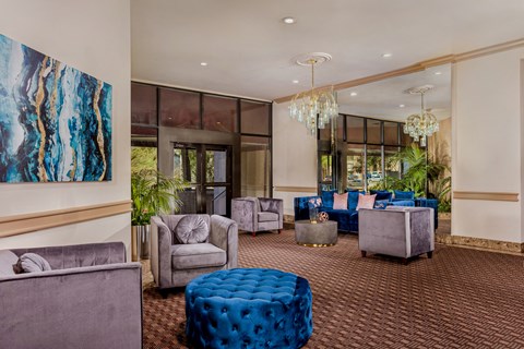 a lobby with couches and chairs and a chandelier