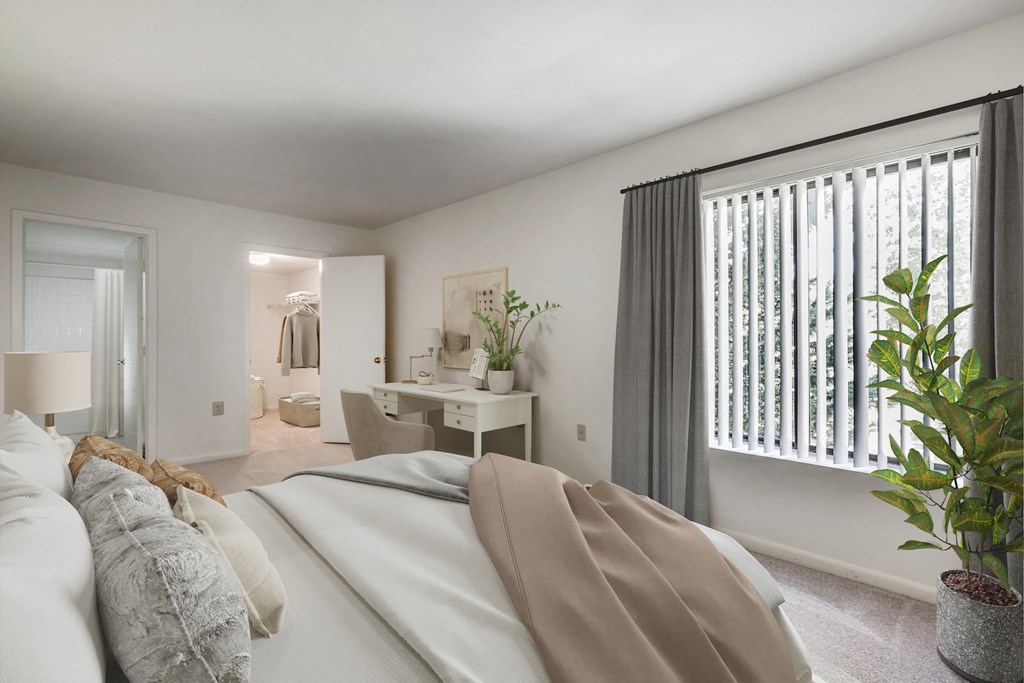 a bedroom with a large bed and a desk with a chair