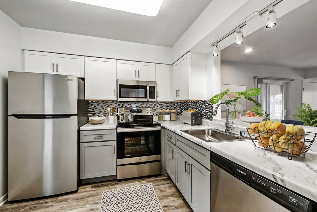 a kitchen with stainless steel appliances and marble counter tops