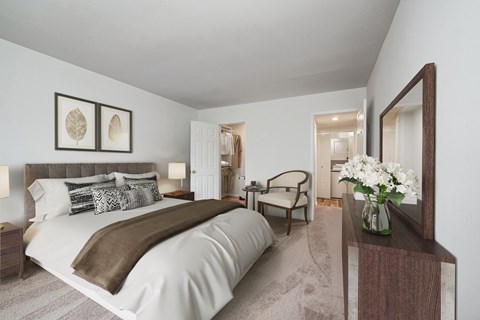 a bedroom with a large bed and a vase of flowers