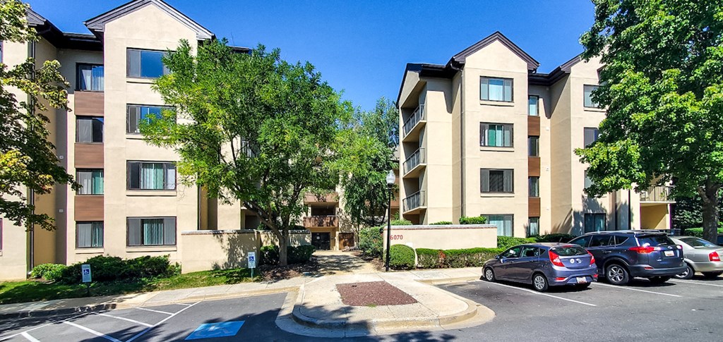 a parking lot with cars in front of an apartment building