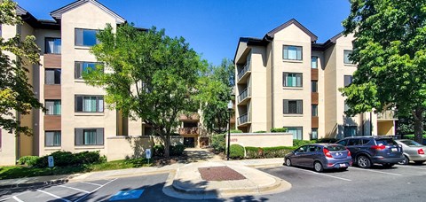 a parking lot with cars in front of an apartment building