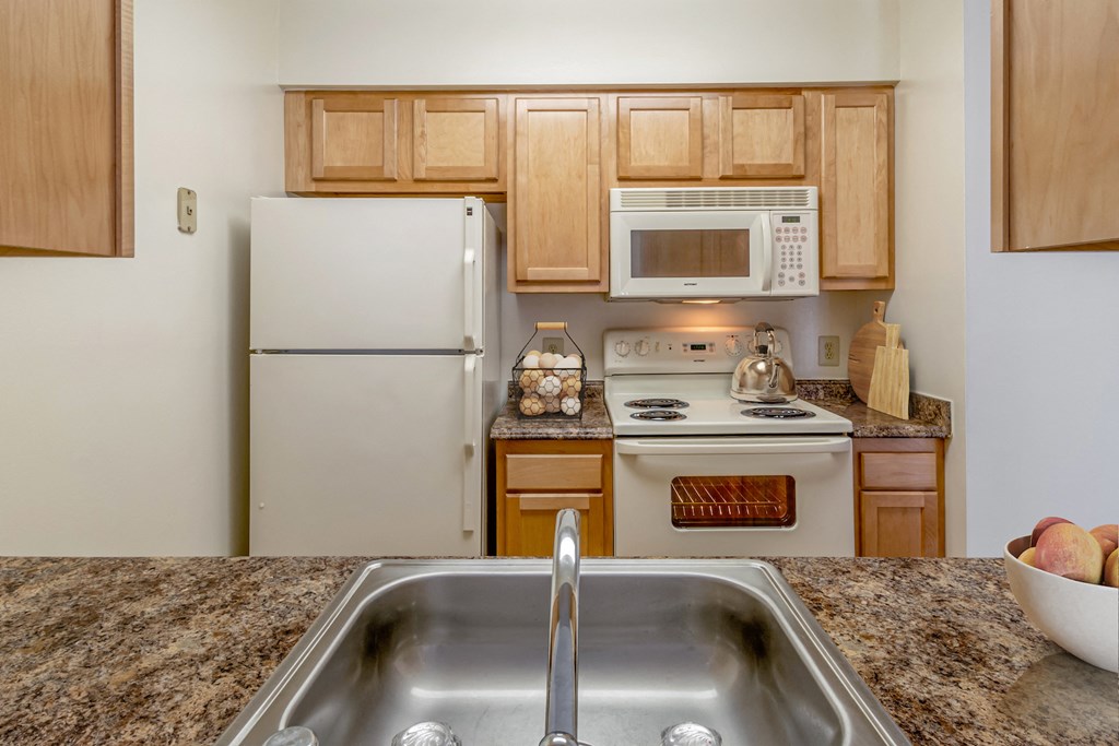 a kitchen with white appliances and granite counter tops