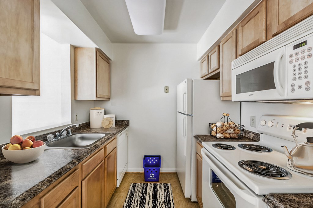 a kitchen with white appliances and wooden cabinets