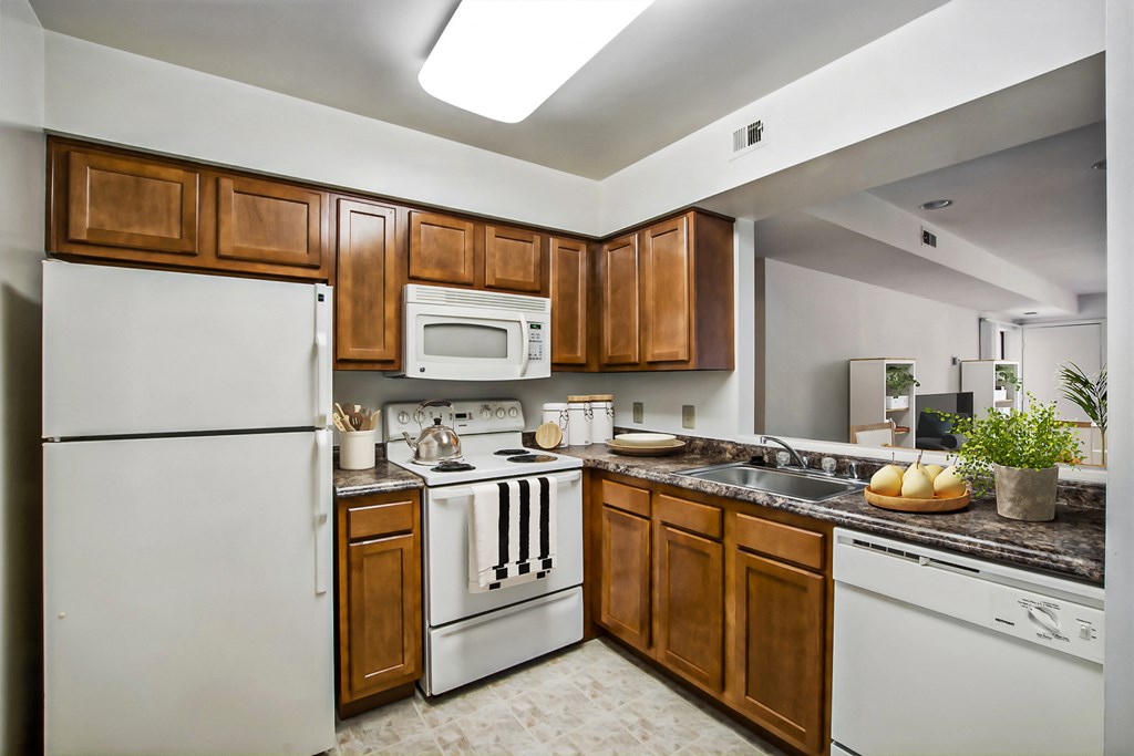 a kitchen with white appliances and wooden cabinets